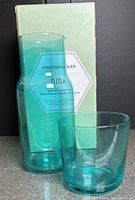 Carafe and cup in front of box