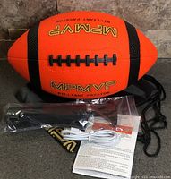 Orange MPMVP LED football with accessories laid out