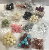 Multiple small bags containing various coloured 15 mm silicone beads