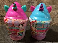 Front view of both sealed Smooshy Mushy Unicorn Shakes cups