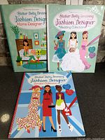 Group shot of three Usborne Sticker Dolly Dressing Fashion Designer books
