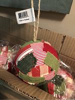 Close view of one patchwork ornament showing fabric patterns and twine loop with tag