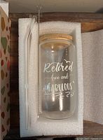 Cup set showing glass cup with etched retirement message, bamboo lid, straw and brush in foam insert