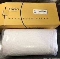 Branded Love's Cabin box with rolled quilt inside plastic