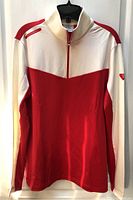 Front view of LPGA red and cream quarter-zip long-sleeve top on hanger