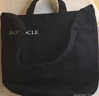 Front view showing Monocle logo, shoulder strap and handles