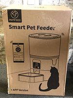 Front of sealed box showing PAPIFEED Smart Pet Feeder graphic and cat icon