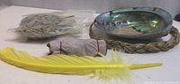 Full kit showing abalone shell in sweetgrass stand, sealed sage bag, sage smudge stick and yellow feather
