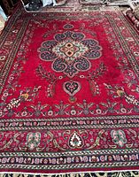 Full view of red Persian Tabriz rug showing size and border