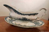 right side view of gravy boat on underplate showing pattern and handle