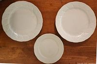 Front view of two dinner plates and one side plate showing Shells border