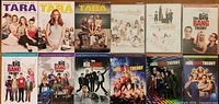 All twelve DVD season sets laid out: top row United States of Tara Seasons 1-3, Modern Family Seasons 2-3; bottom row The Big Bang Theory Seasons 1-7