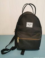 Front view showing logo patch, front pocket, zipper, overall condition