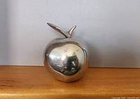 Front view of polished aluminum apple sculpture