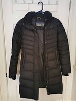 Front view of black Lole down coat on hanger showing overall style and length