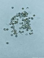 Group of loose round diamonds scattered on white background
