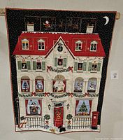 Front view of quilt showing townhouse design and numbered pockets