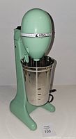 Front view of mint green Hamilton Beach drink mixer with stainless cup