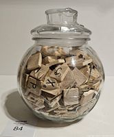 Jar filled with Scrabble tiles, lid on