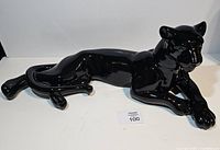 Full side view of glossy black ceramic reclining panther