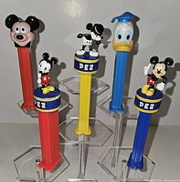 Front view five Pez dispensers showing character tops and stem colors