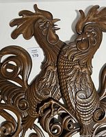Both pressed iron rooster wall decor pieces showing overall design