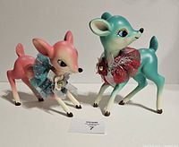 Front view of both pastel resin fawn figurines standing