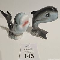 Front view of both ceramic whale shakers