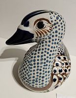 Left profile of hand-painted ceramic duck showing blue dotted design