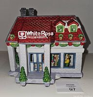 Front view showing White Rose sign, porch, trees