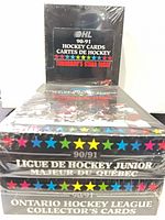 Stacked view of three sealed hockey card boxes showing titles and shrink-wrap