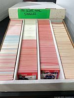 Open long cardboard box filled with three rows of 1991 Score NHL single trading cards