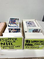 Two storage boxes with labelled dividers showing 1993 Upper Deck NHL Complete Set #1-310 and 1991 Upper Deck NHL Full Set #1-500