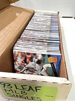 Open cardboard box showing row of 1993 Leaf baseball cards, front card features pitcher in Dodgers uniform.