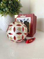 Ornament displayed beside box showing design and ribbon