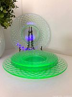 Two plates displayed upright and two stacked, showing uranium glow under UV light