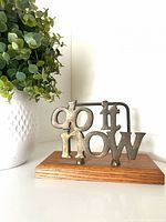 Front view showing brass letters and wood base