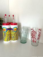 Three plastic tumblers, green glass, clear plastic glass