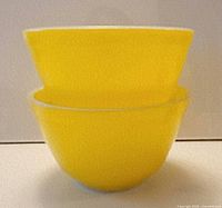 Two yellow Pyrex bowls stacked, showing color and interior contrast