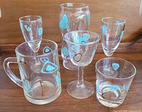 Group shot of all six glasses showing varying shapes and matching turquoise/brown amoeba motif