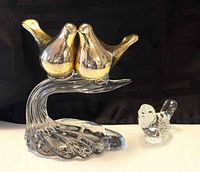 Front view of brass bird sculpture and clear glass owl