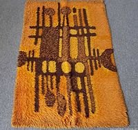 Full view of orange and brown rya shag rug laid flat