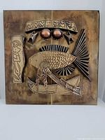 Full view of square metal panel with fish relief