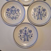 Four dinner plates and one smaller plate showing full pattern