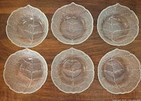 Top view of six clear glass leaf bowls showing vein pattern
