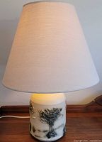 Full view of lamp illuminated with shade