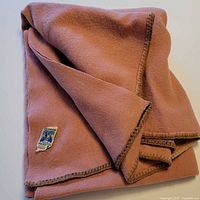 Folded dusty rose Kenwood wool throw showing overall appearance