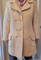 Front view of cream Nicolette wool coat worn by model, showing buttons, lapel and pockets