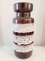 Full view of cylindrical brown and white lava glaze vase