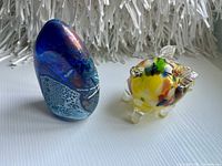 Egg-shaped sculpture and pig figurine front view